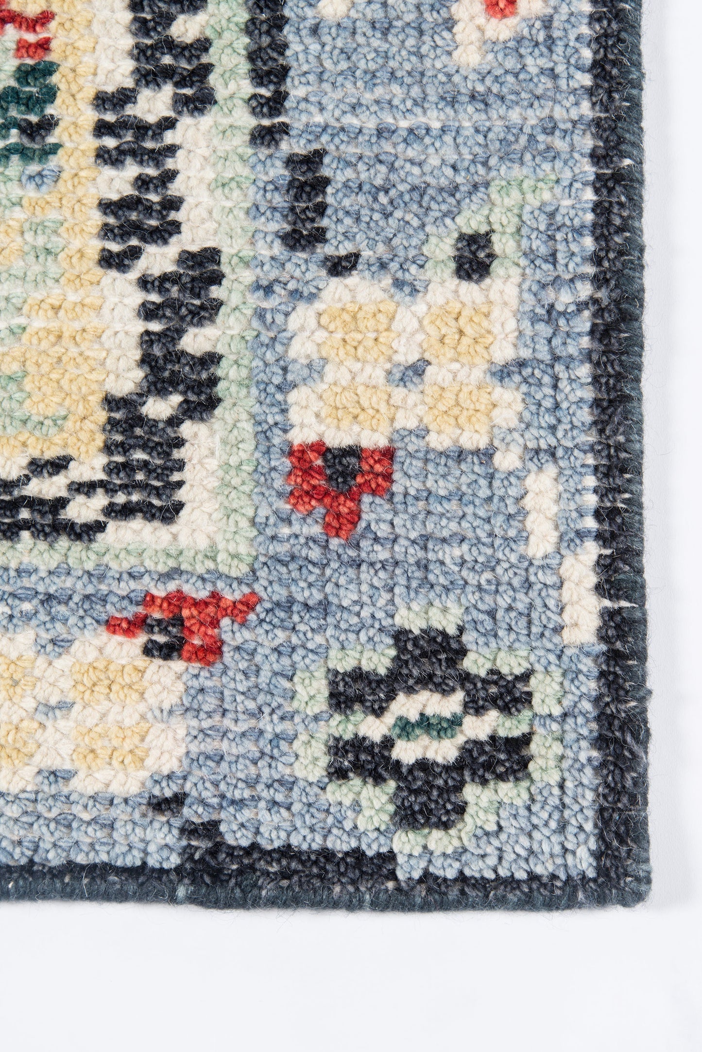 Blue traditional oriental rug corner with floral motifs, cream, yellow and red accents; wool tufted texture