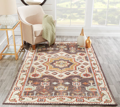 Boho geometric area rug in cream, brown, rust and teal with a central medallion; woven look in a sunlit living room.