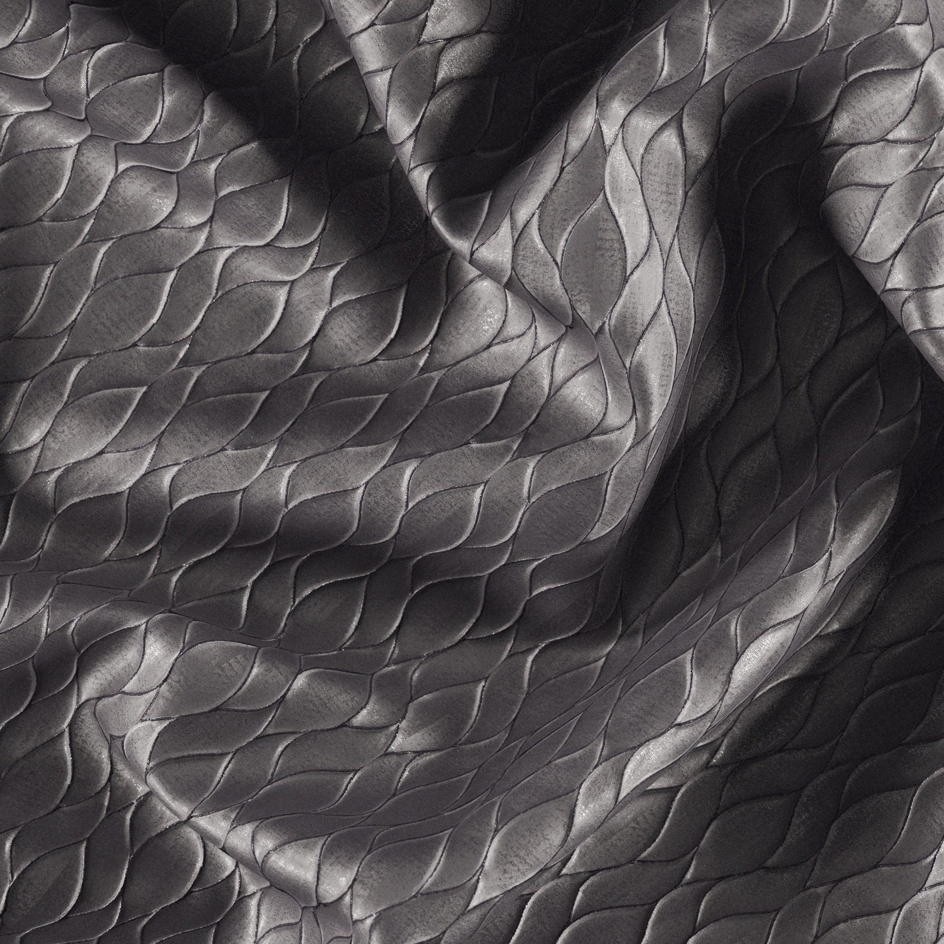 Dark gray jacquard fabric with metallic pewter sheen and abstract ogee pattern, shown in flowing folds.
