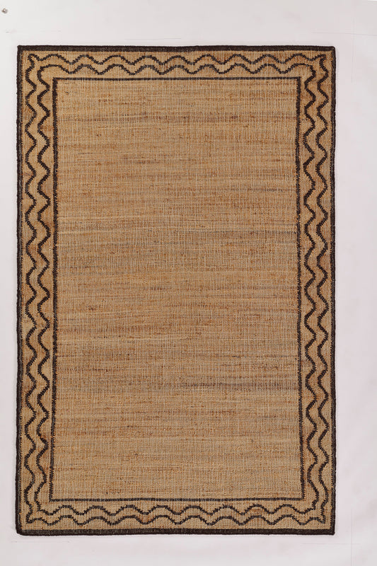 Rectangular natural jute rug with dark brown zigzag border and inner frame; rustic woven beige center.