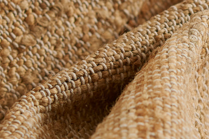 Natural jute rug with chunky braided weave and textured loops; rustic beige rug for living spaces; size 10' x 14'.