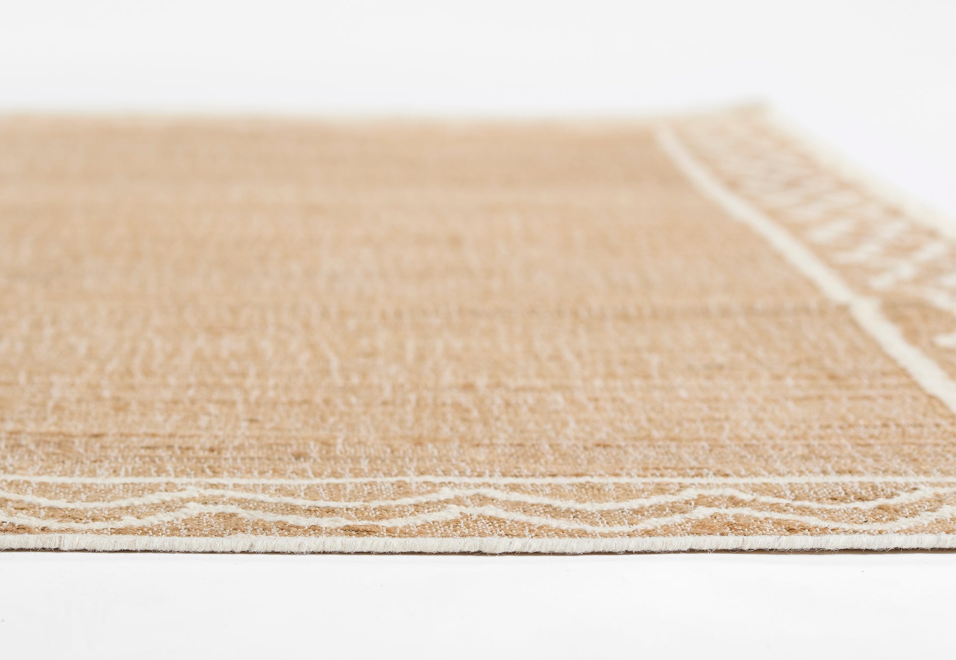 Natural beige jute rug with white woven border, rectangular, rustic coastal style.