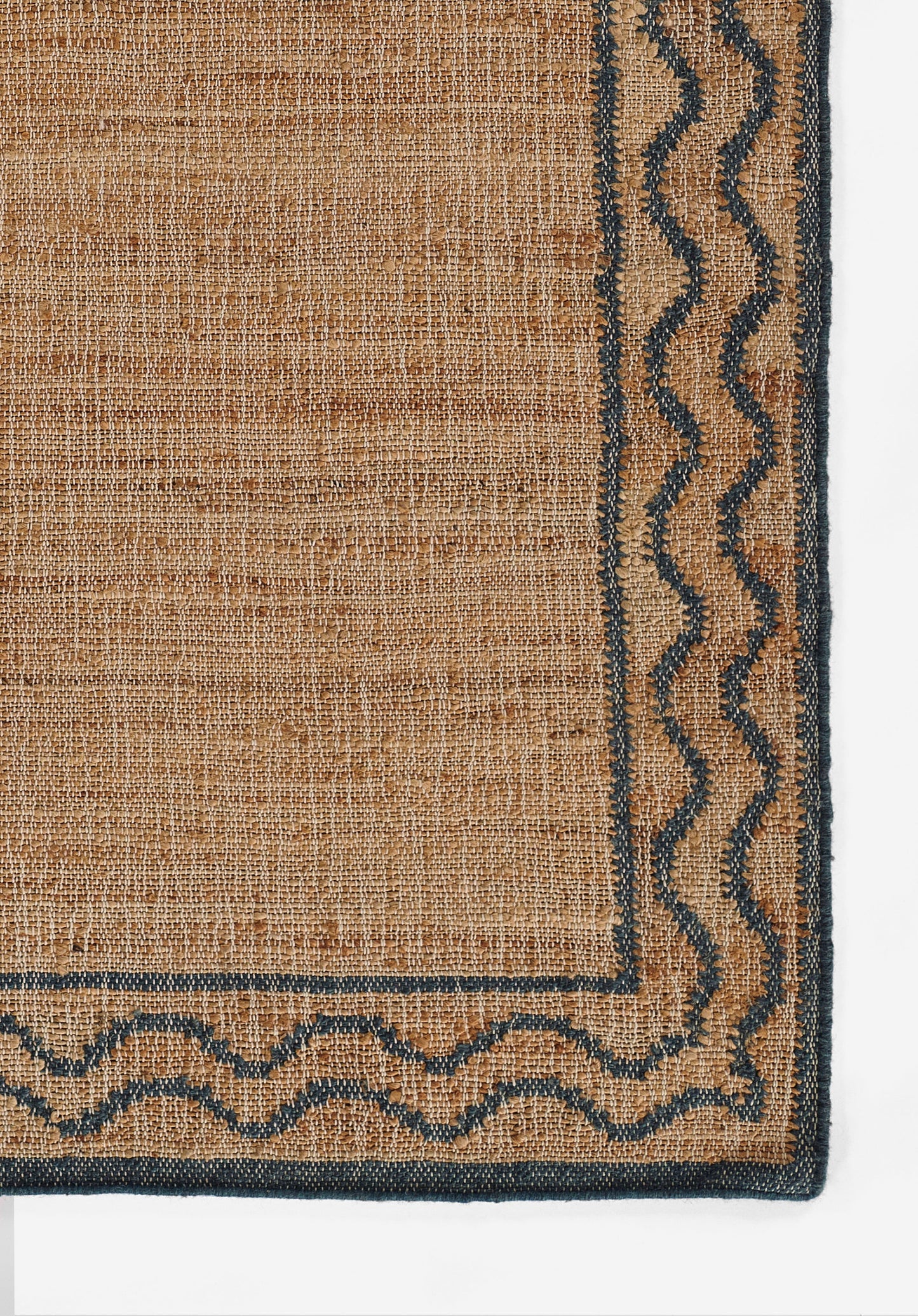 Natural beige jute area rug with navy border and wavy edge trim.