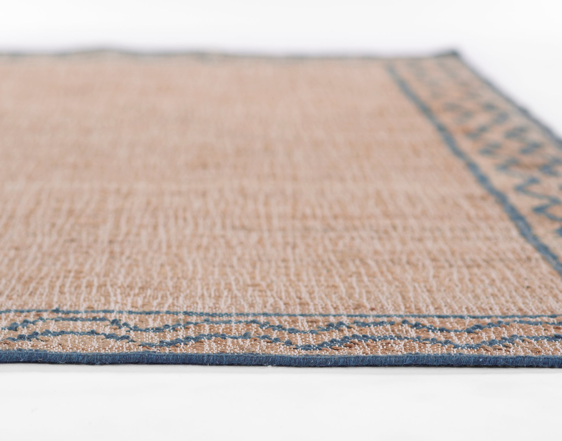 Beige flat-weave jute runner rug with blue border and slim blue edging along the perimeter.