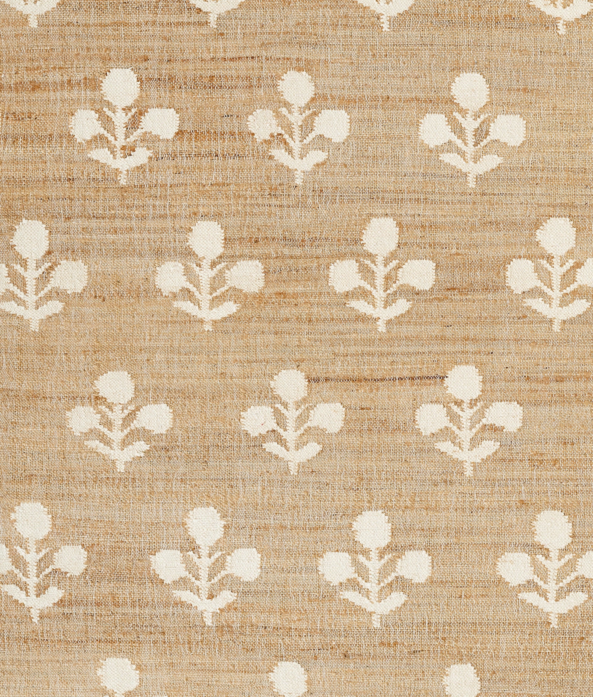 Beige rug with a linen-textured surface and repeating ivory floral motifs in a simple farmhouse pattern, 2' x 3'.