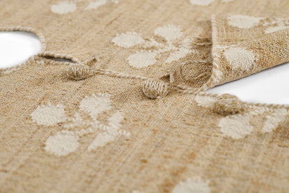 Natural beige circular rug with white spots, woven jute texture, knotted fringe edge, 5' round.