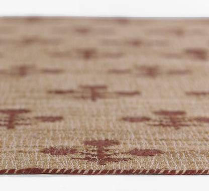 Close-up of a beige woven rug with burgundy diamond motifs and a red braided edge