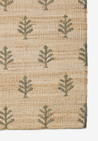 Natural beige woven rug with green fern-like leaf motifs in a repeating pattern.