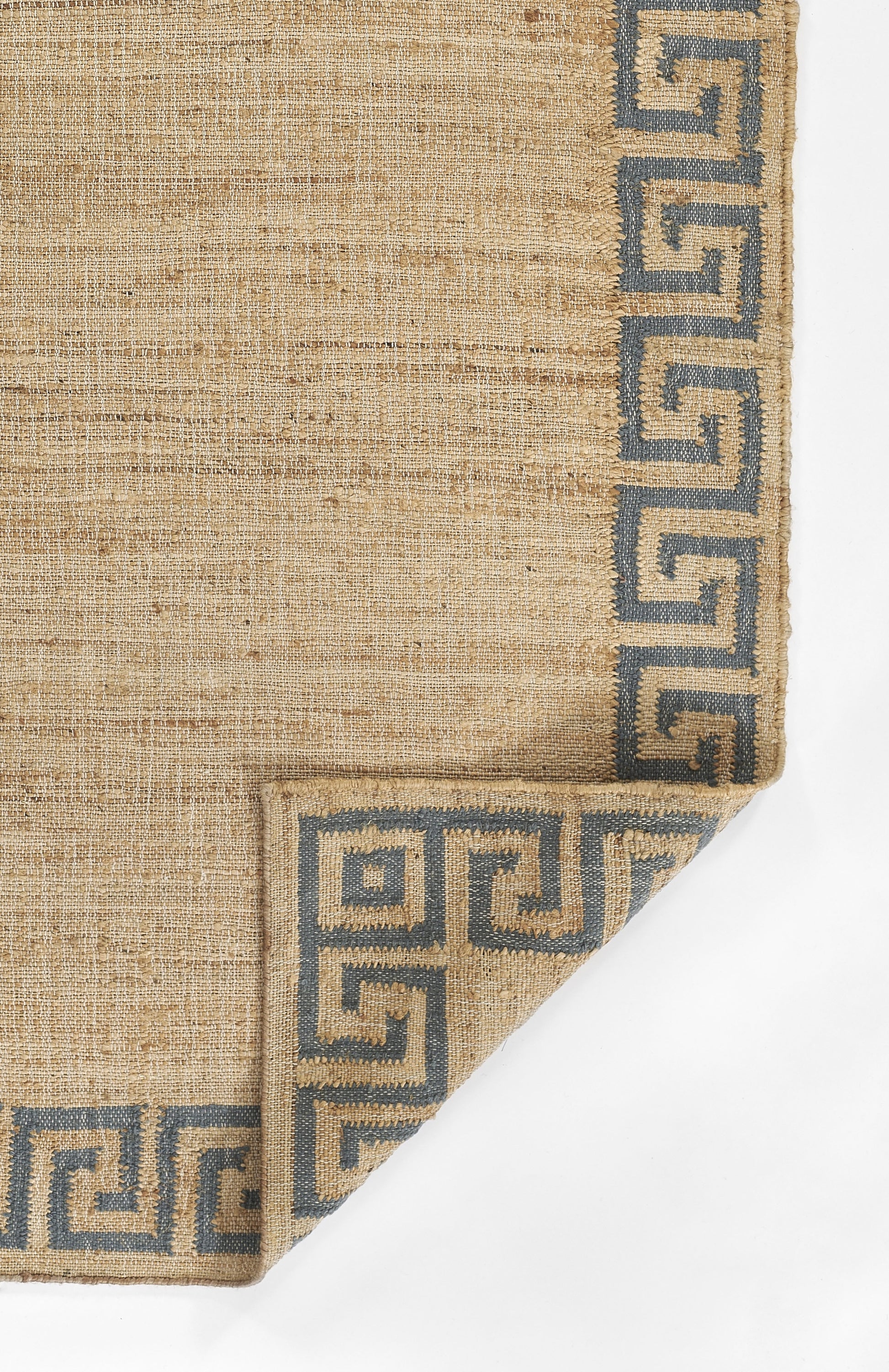 Beige woven rug with blue Greek-key border along edges; folded corner.