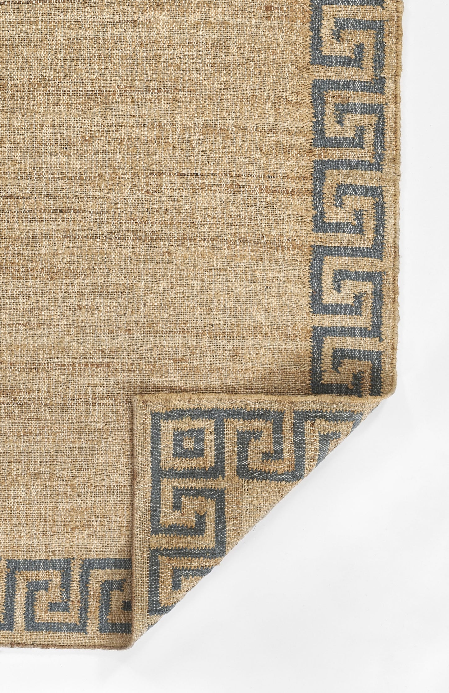 Natural beige woven rug with blue Greek key border; textured jute fibers and folded corner.