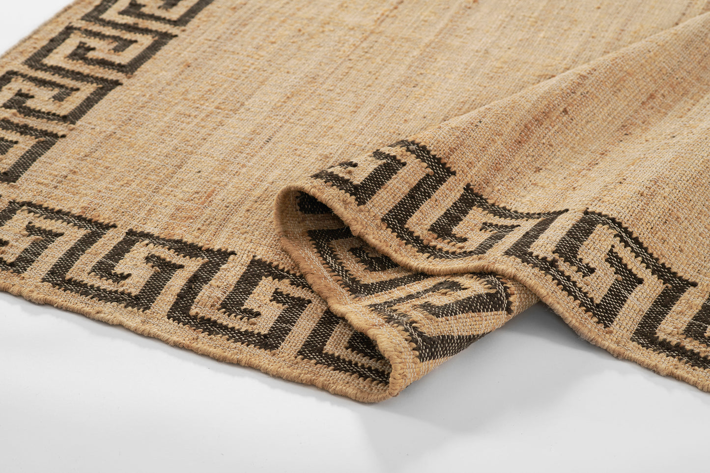 Natural jute rug with a dark brown Greek key border; handwoven, rustic texture.