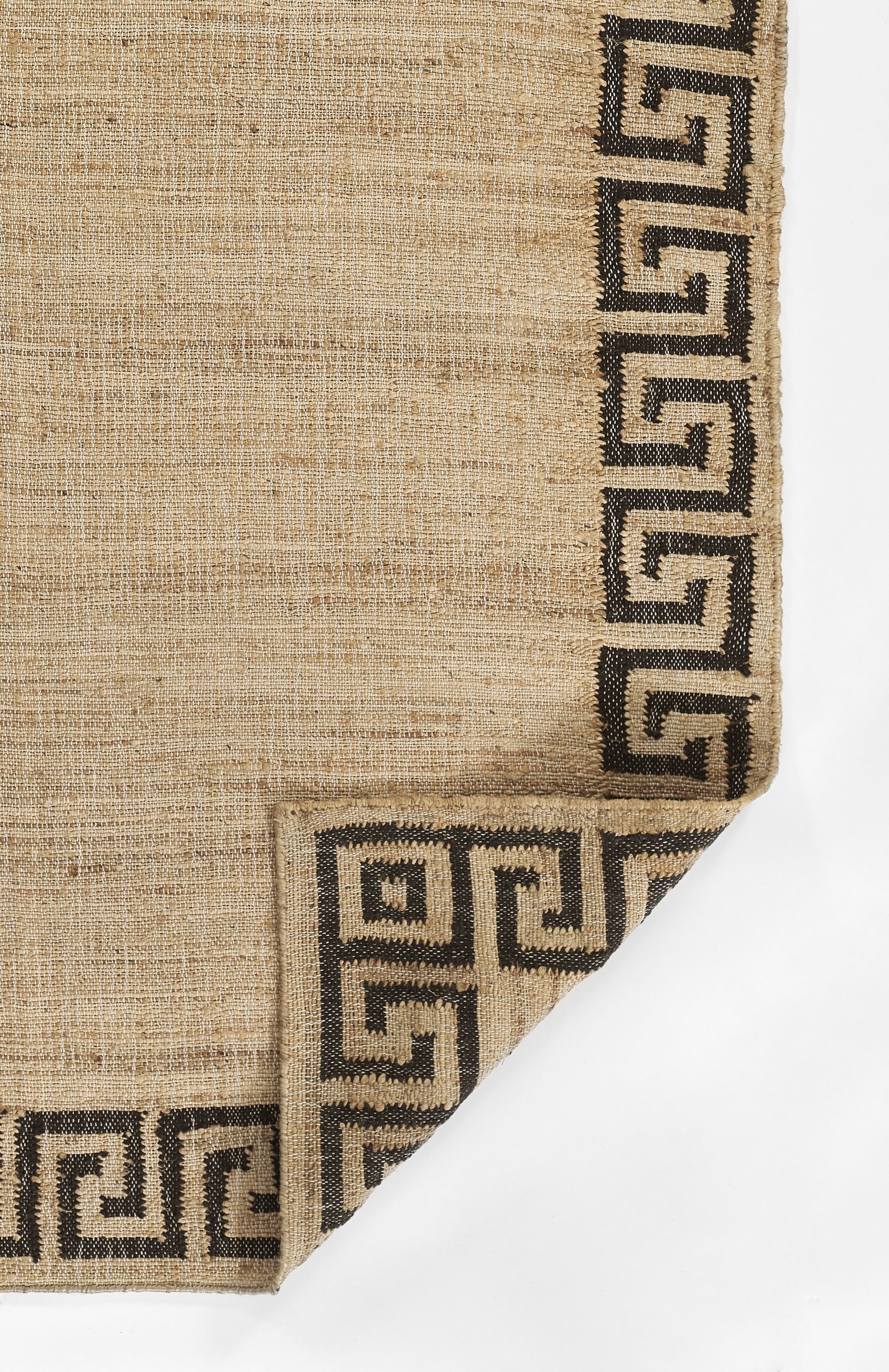 Beige natural-fiber rug with black Greek-key border along edges; folded corner shows border pattern.