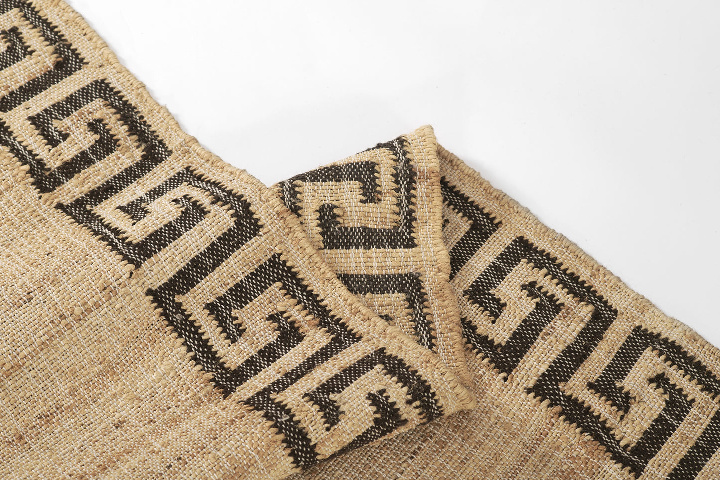 Natural jute rug with black Greek-key border; rectangular, woven texture, boho geometric style.