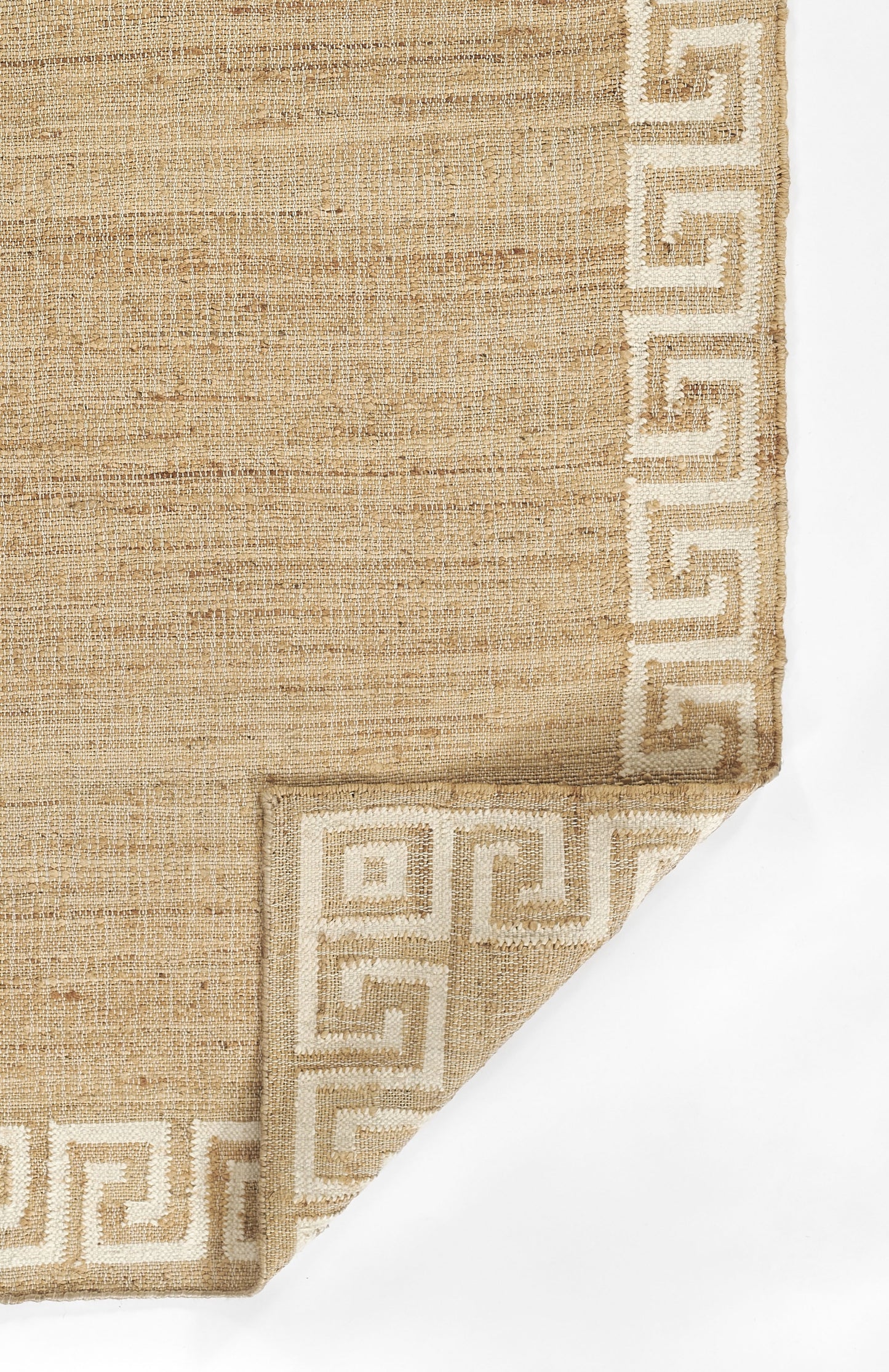 Natural jute rug with ivory Greek key border and woven texture, folded corner.