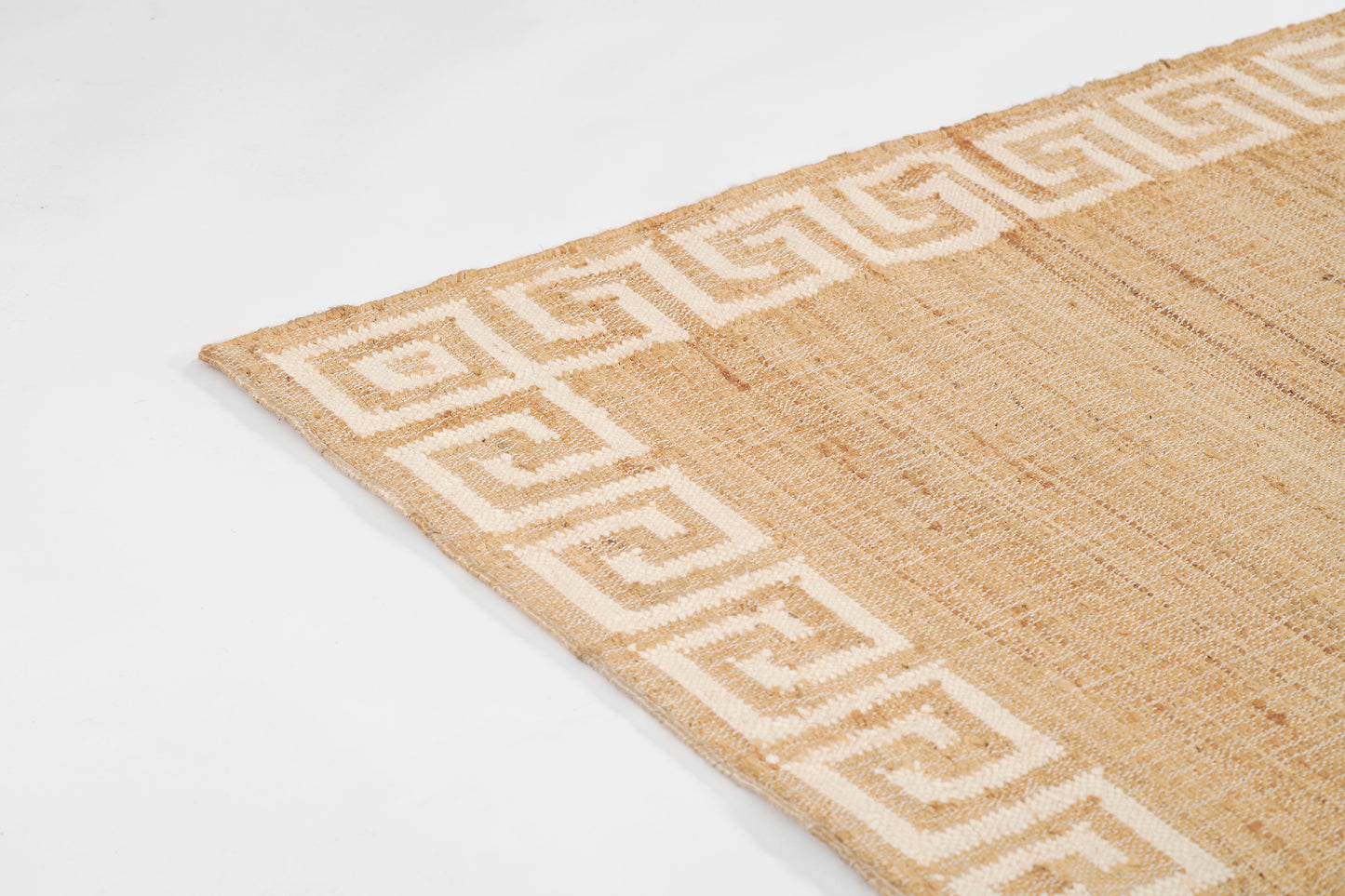 Natural jute rug with white Greek-key border, rectangular and earthy, ideal coastal floor decor.