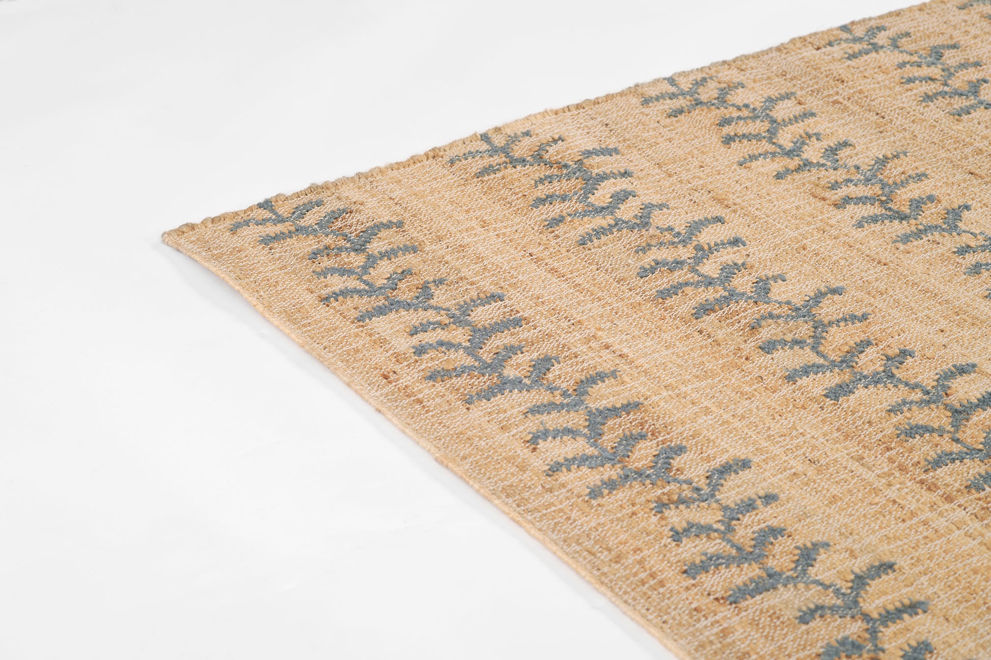 Beige woven jute rug with blue leaf-pattern stripe, natural boho style.