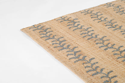 Beige woven rug in natural fibers with blue vine stripe motif; corner detail