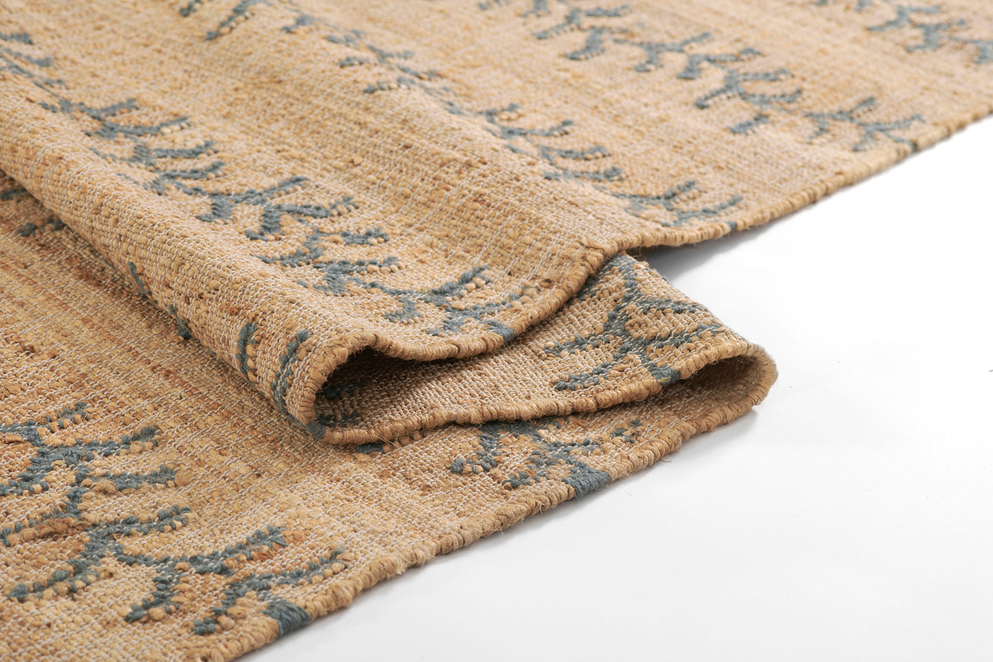 Beige woven rug with blue geometric motif, jute-like texture, rolled edge for cozy floor decor