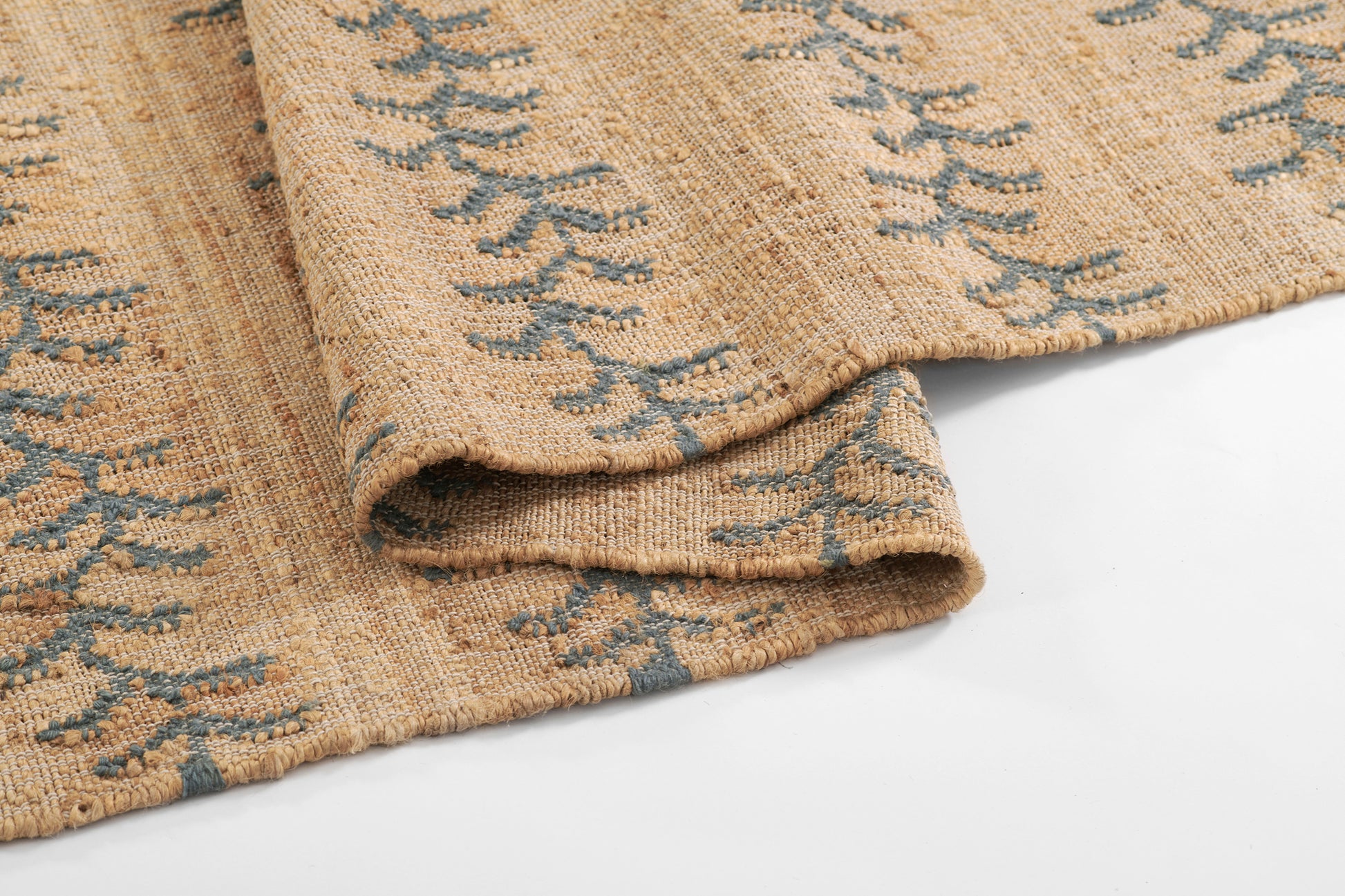 Beige rug with blue vine stripe pattern, soft texture.