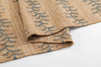 Beige rug with blue vine stripe pattern, 5' x 8', folded to show a soft, textured weave.