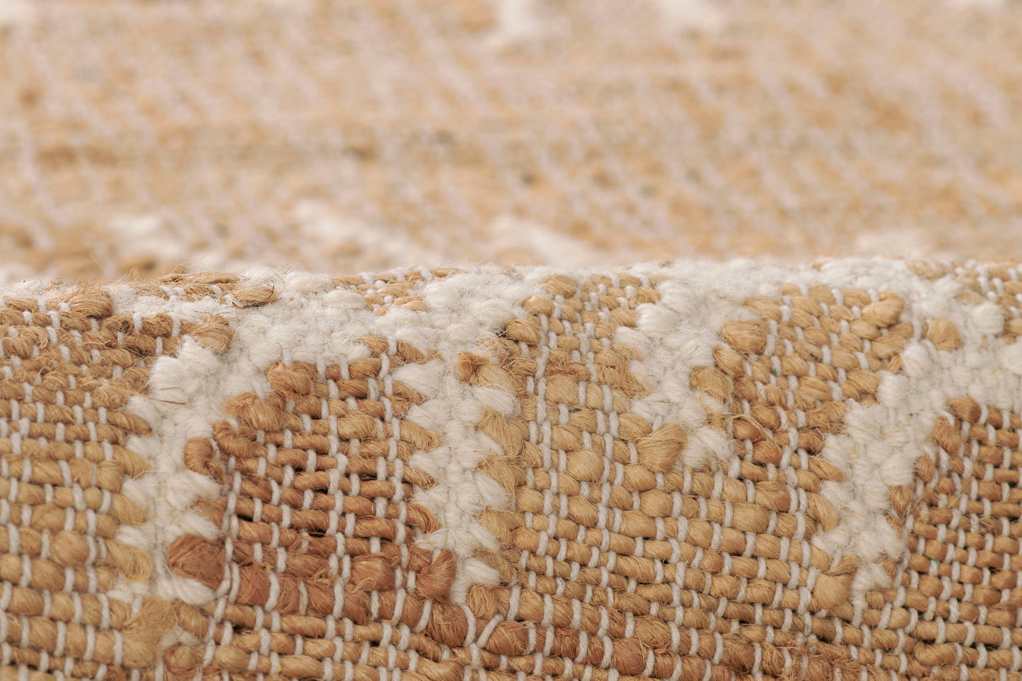 Close-up of natural beige and ivory woven jute runner with geometric pattern and chunky texture.
