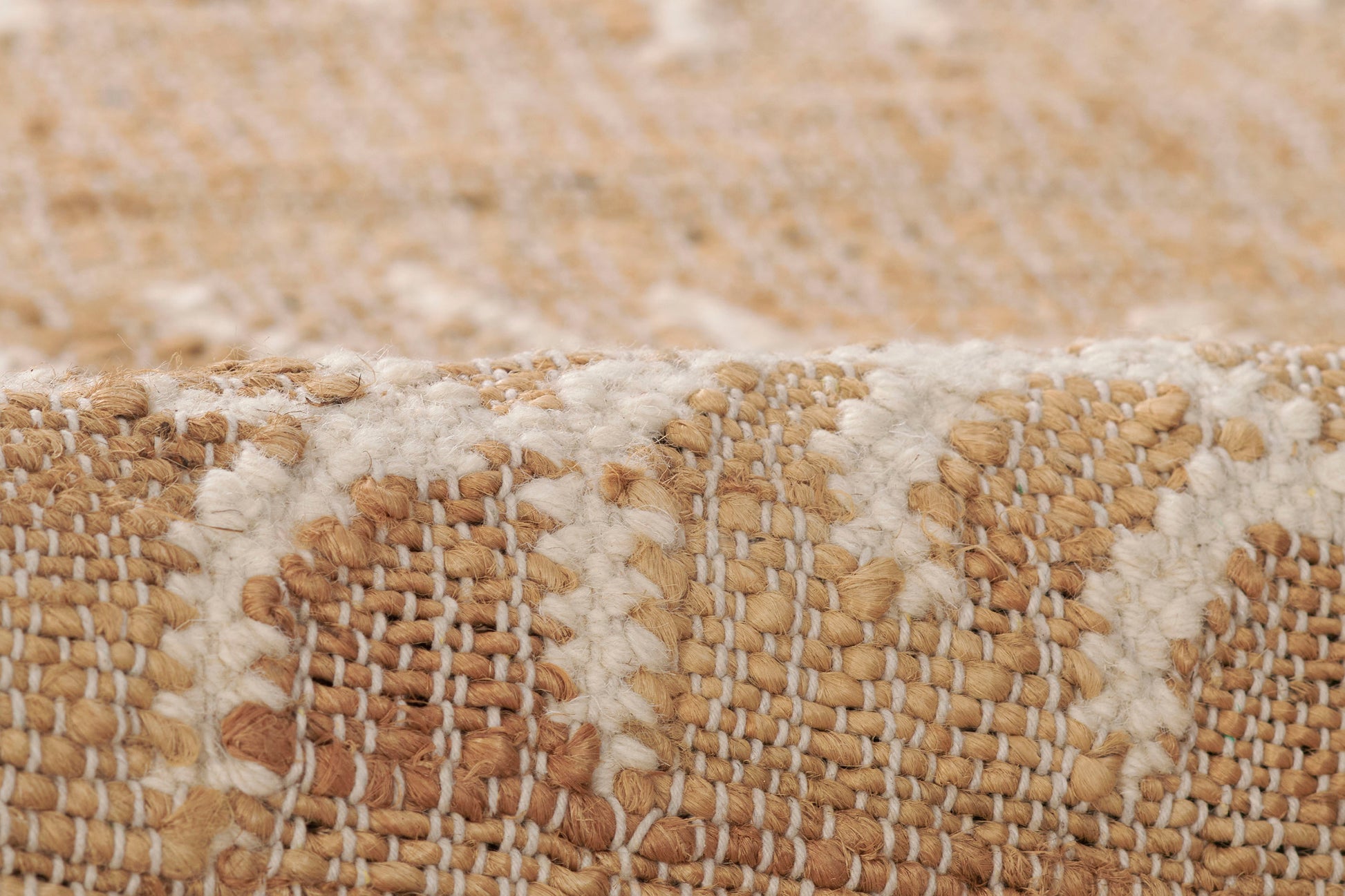Close-up of natural beige and ivory woven jute runner with geometric pattern and chunky texture.