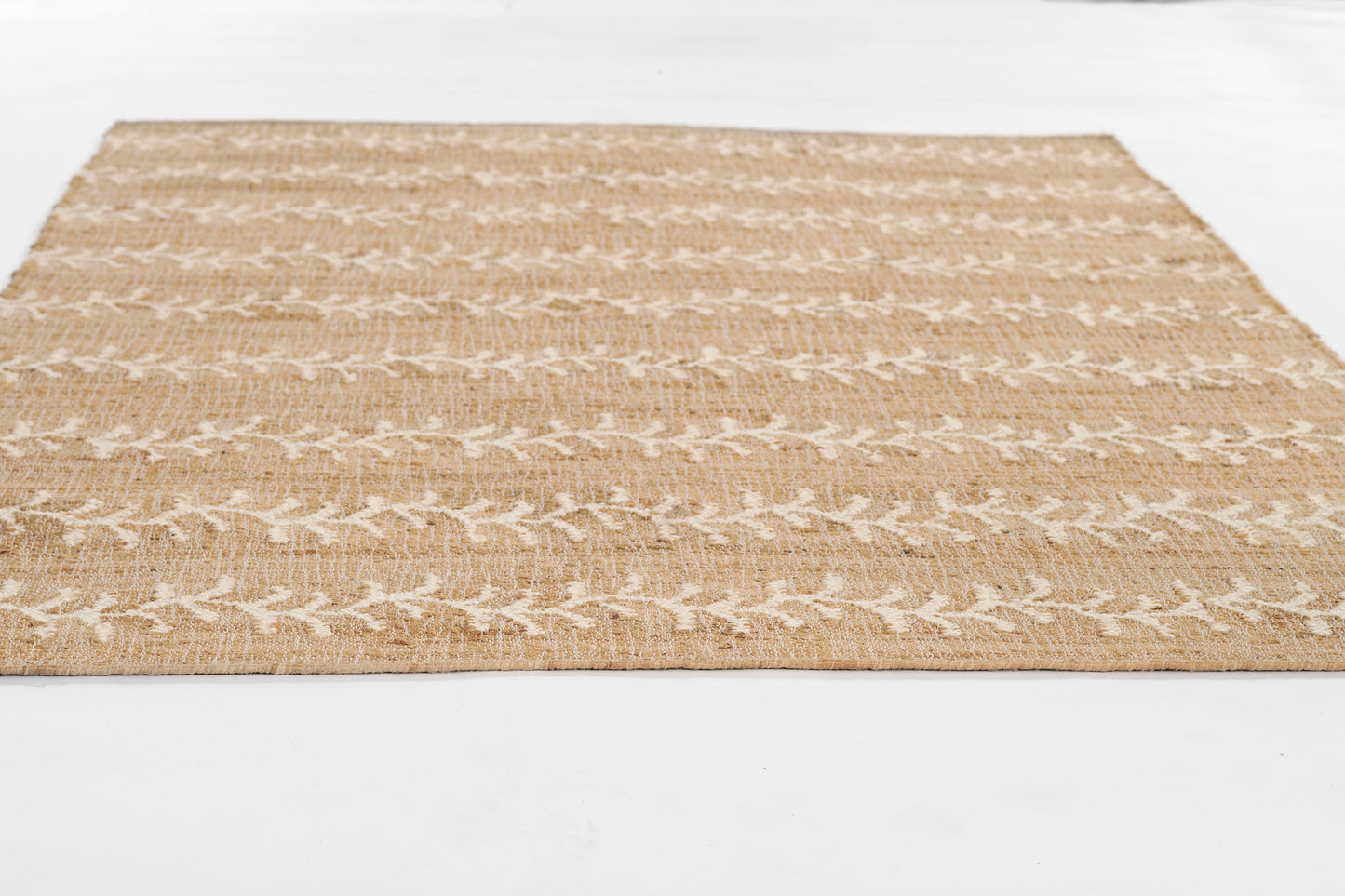 Natural beige jute rug with white leaf vine pattern in horizontal stripes; rectangular, casual coastal style.
