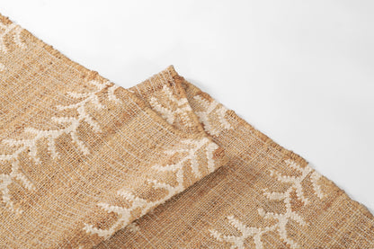 Natural burlap rug with woven texture and white embroidered vine stripe pattern, 9' x 12'.