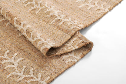 Beige natural-fiber woven rug with white botanical vine stripe pattern, folded in soft layers.