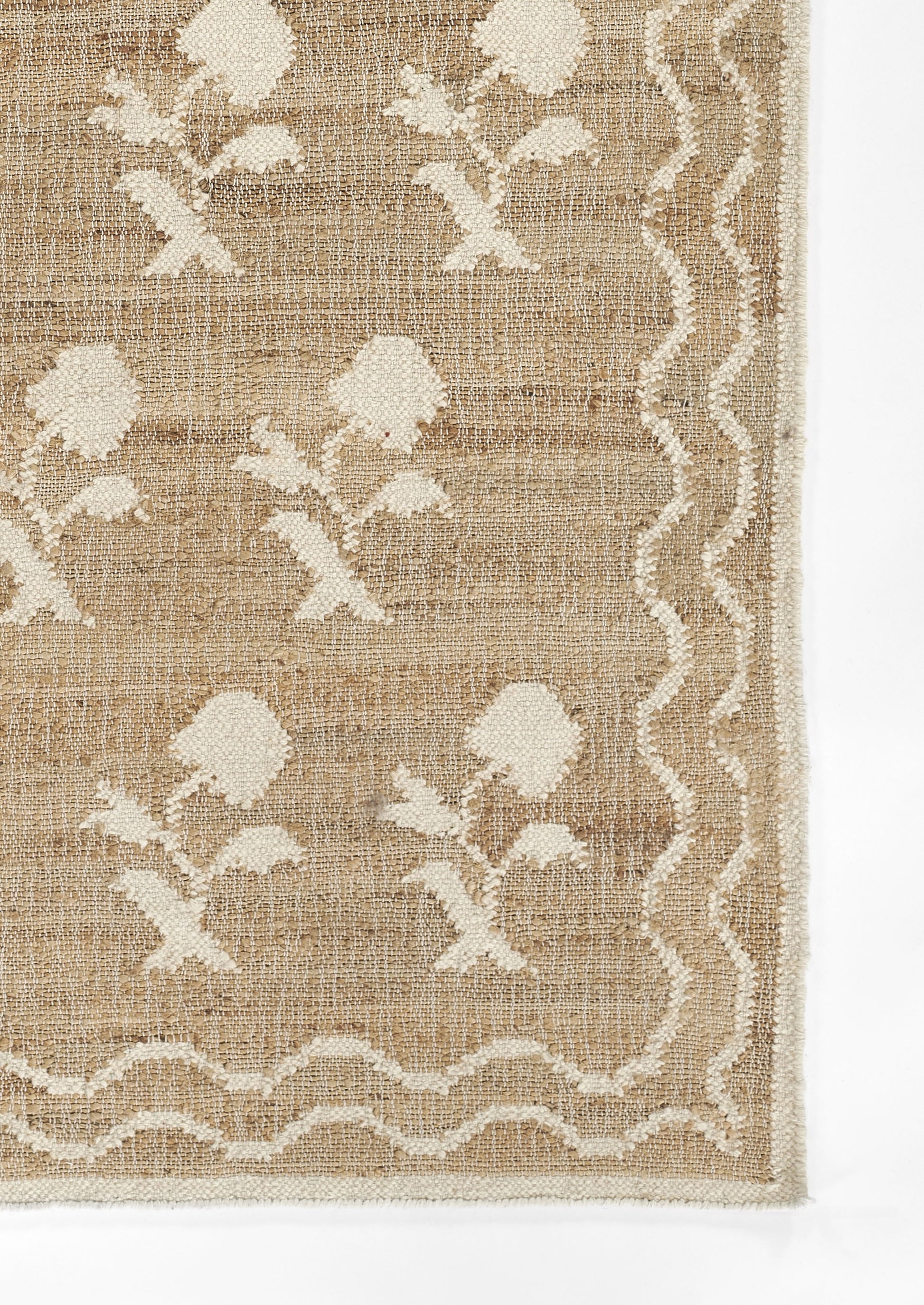 Beige jute rug with white floral vines and a scalloped border along edges.