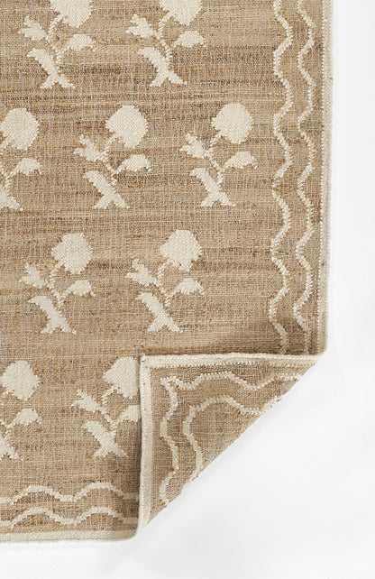 Natural beige jute-like rug with ivory floral motifs and a white wavy border; rectangular, folded corner shows backside.