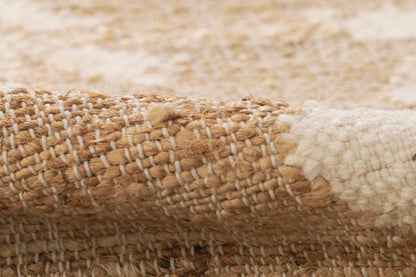 Close-up of a natural jute rug in tan and ivory with a chunky woven texture.