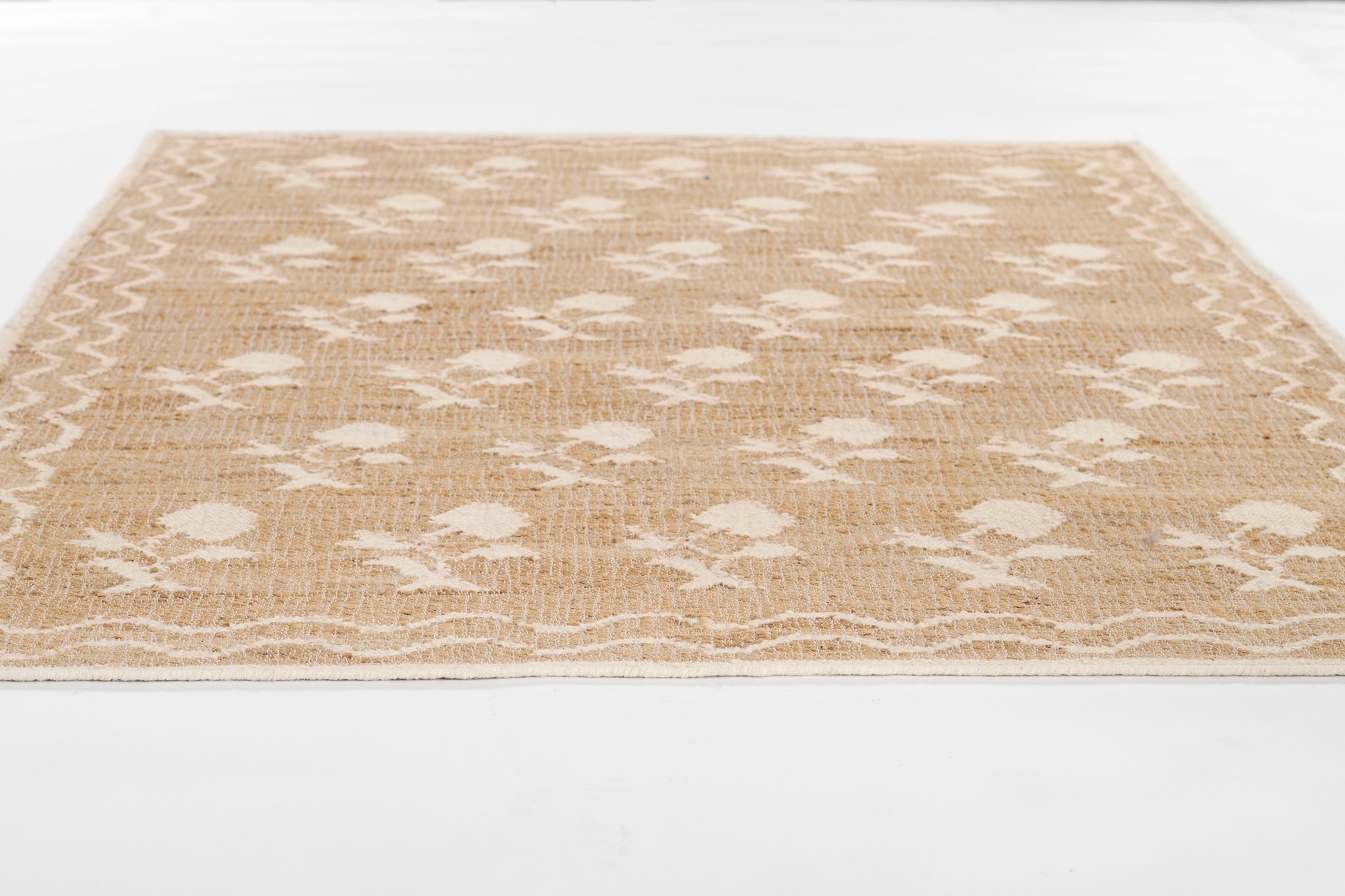 Natural beige jute rug with white flower motifs and decorative border, rectangular area rug.