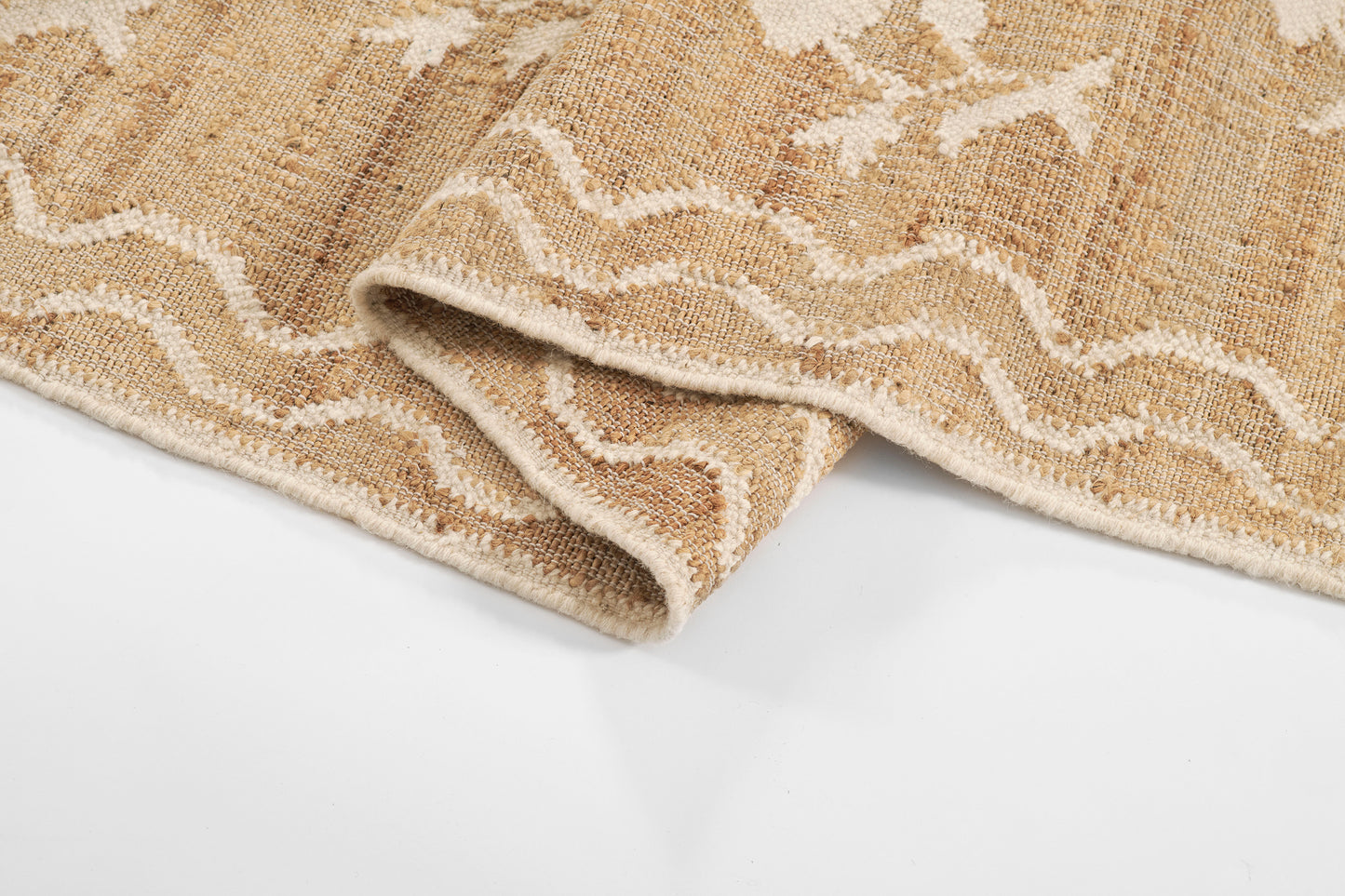 Beige woven rug with white wavy stripe pattern, textured jute-like surface and folded edge.