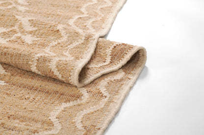 Beige woven rug with cream zigzag pattern, folded edge, soft textured textile.