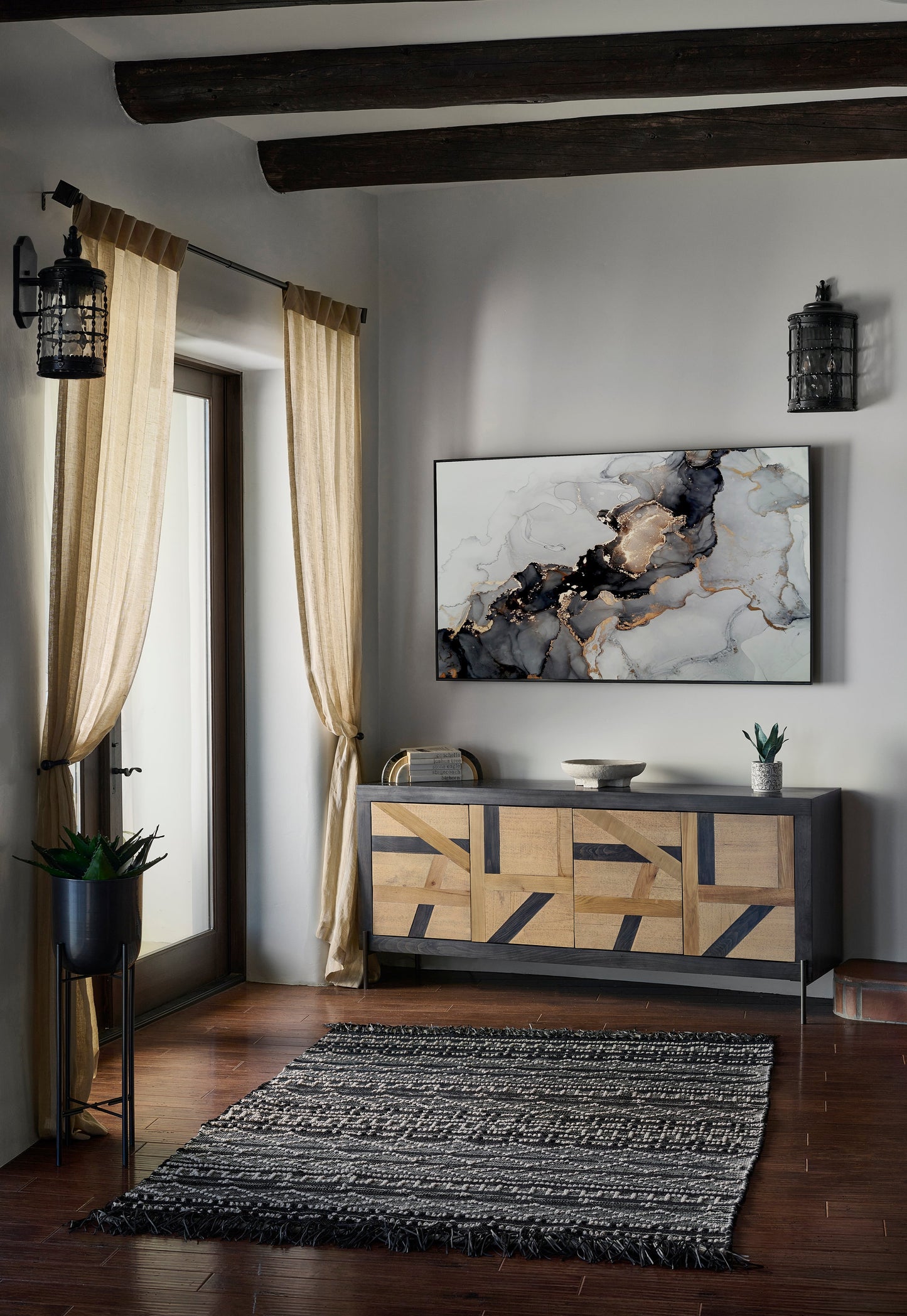 Geometric-pattern area rug on the floor with neutral decor and wall art visible in the background.
