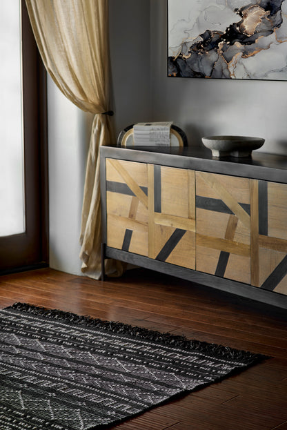 Geometric tan rug with black accents on a living room floor.