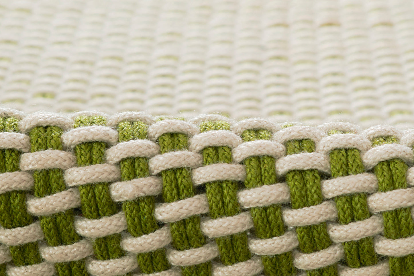 Close-up of green and cream woven textile with chunky braided pattern.