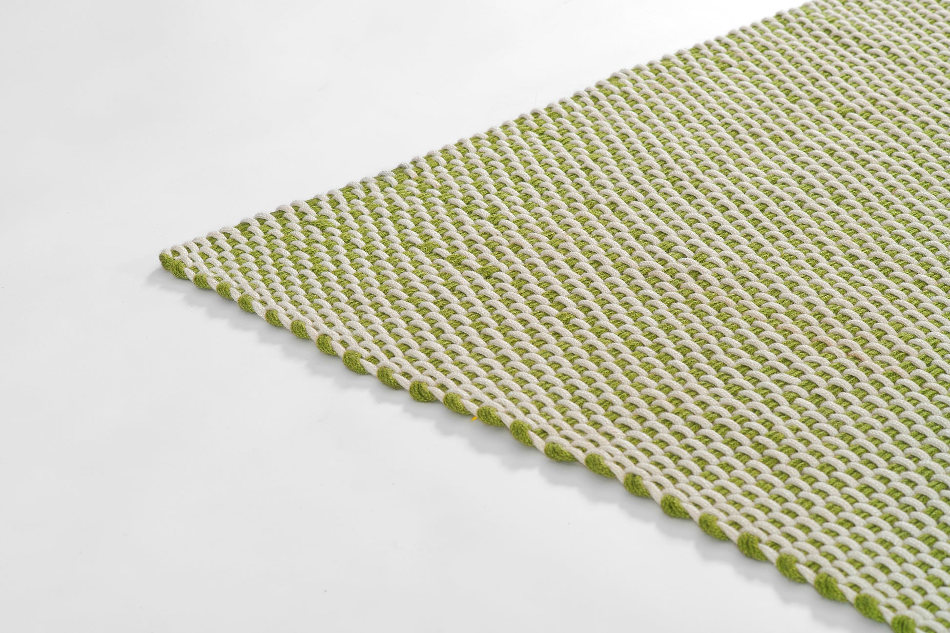 Green and white woven paracord rug with looped border, textured for kitchen or bathroom.