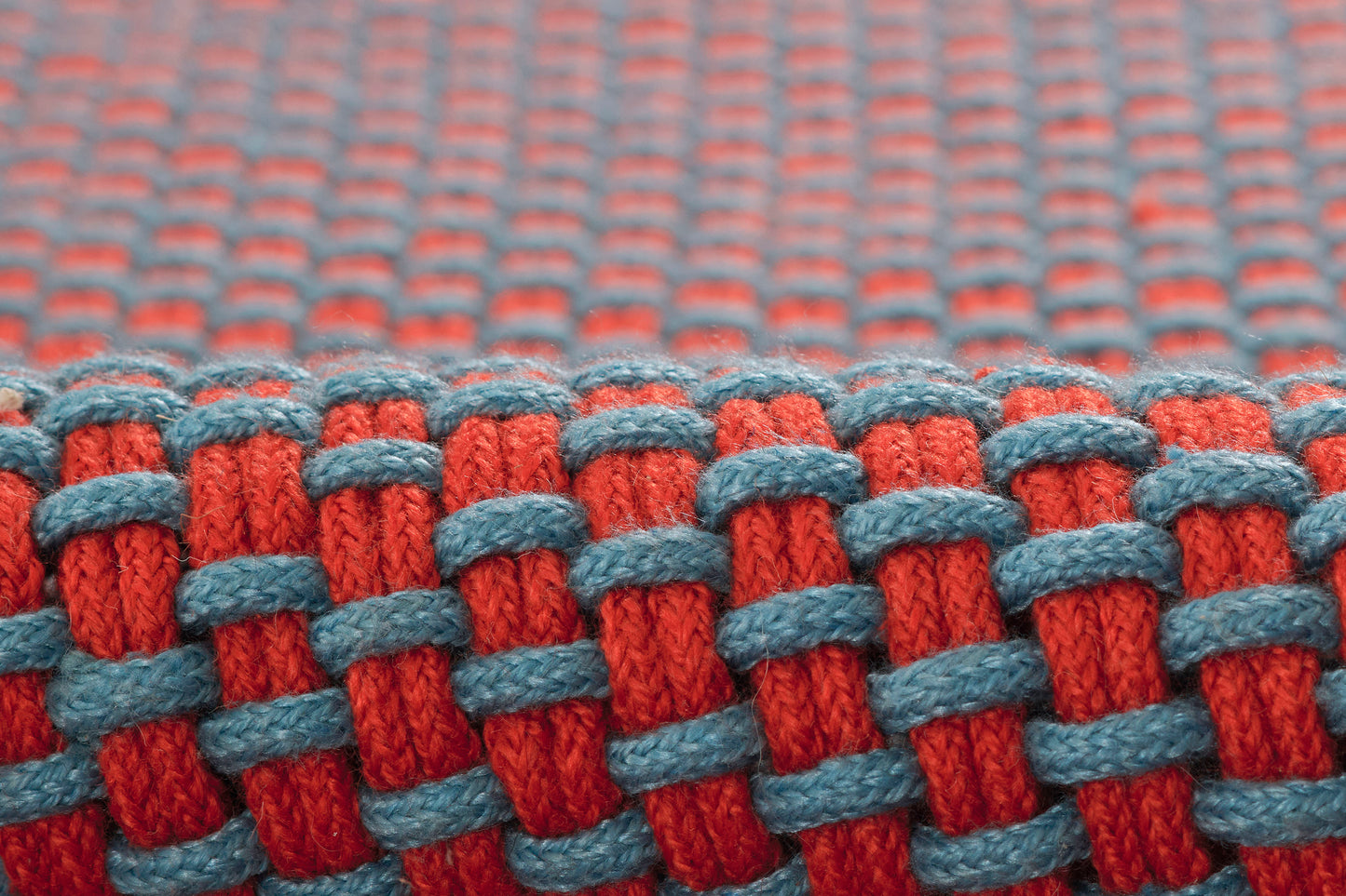 Macro shot of red and blue paracord woven braid on a rug runner.