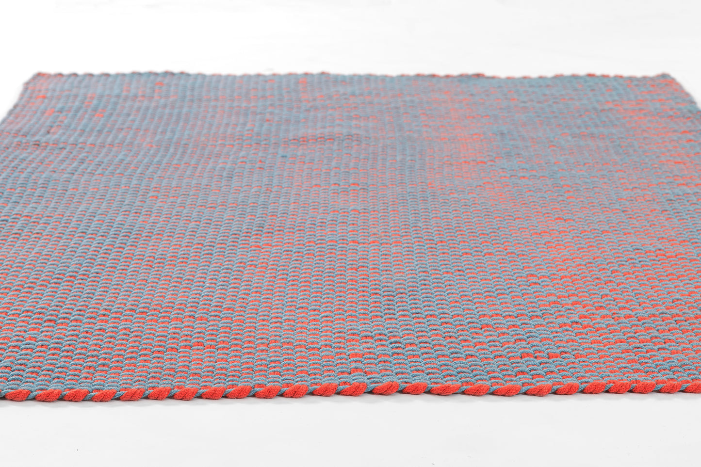 Blue and red woven paracord rug with orange braided edging, rectangular outdoor rug.