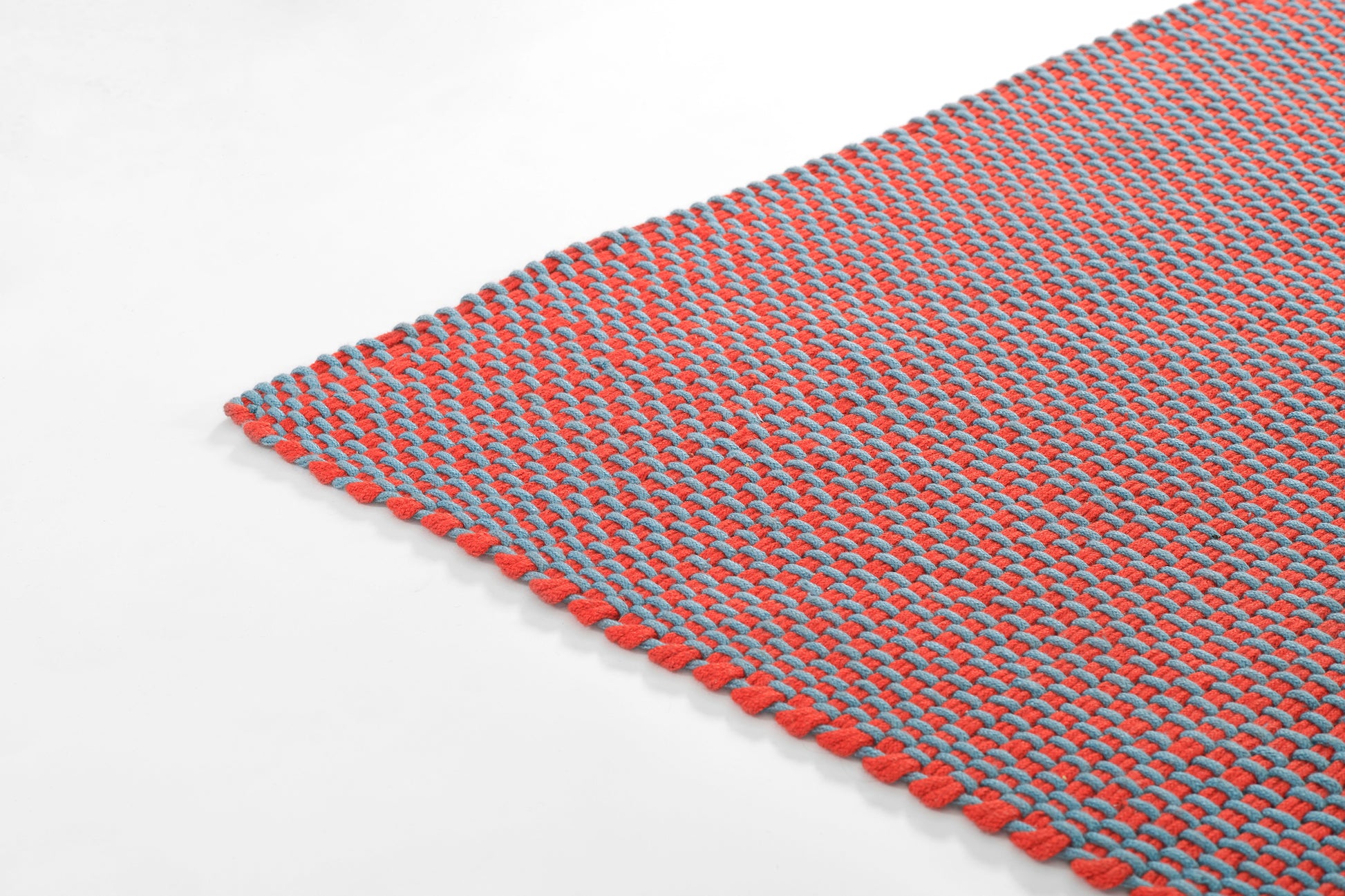 Red and blue paracord woven placemat with red fringe edge, rectangular, casual table decor.