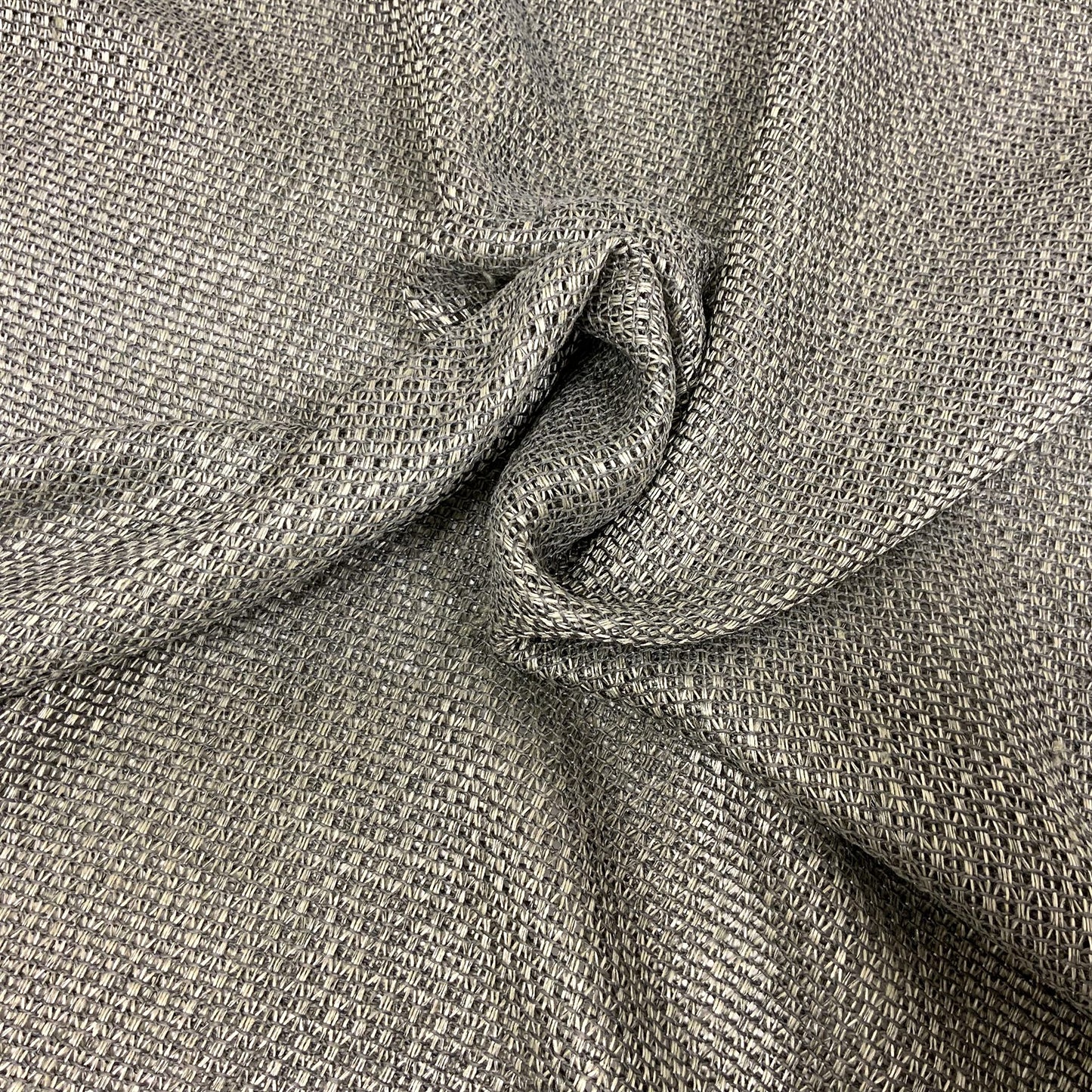 Paragon gray woven fabric with subtle texture and soft drape, shown twisted; ideal for upholstery or apparel.