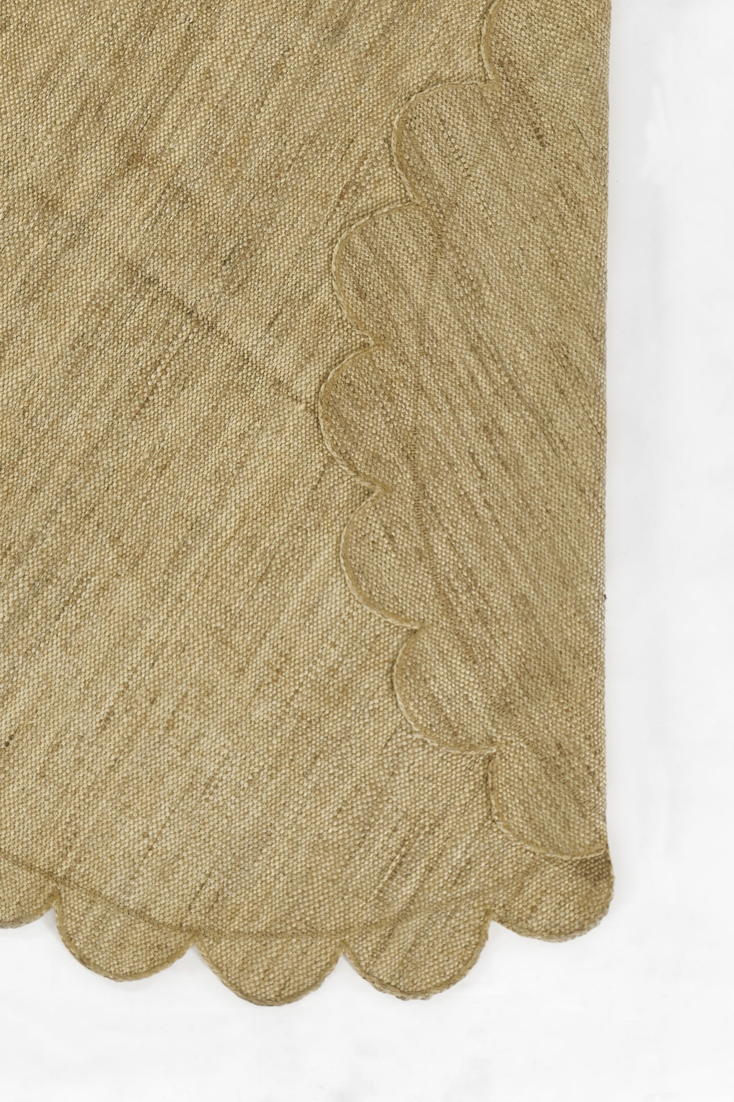 Natural beige knitted fabric with scalloped edge; textured soft material for scarf or table runner.