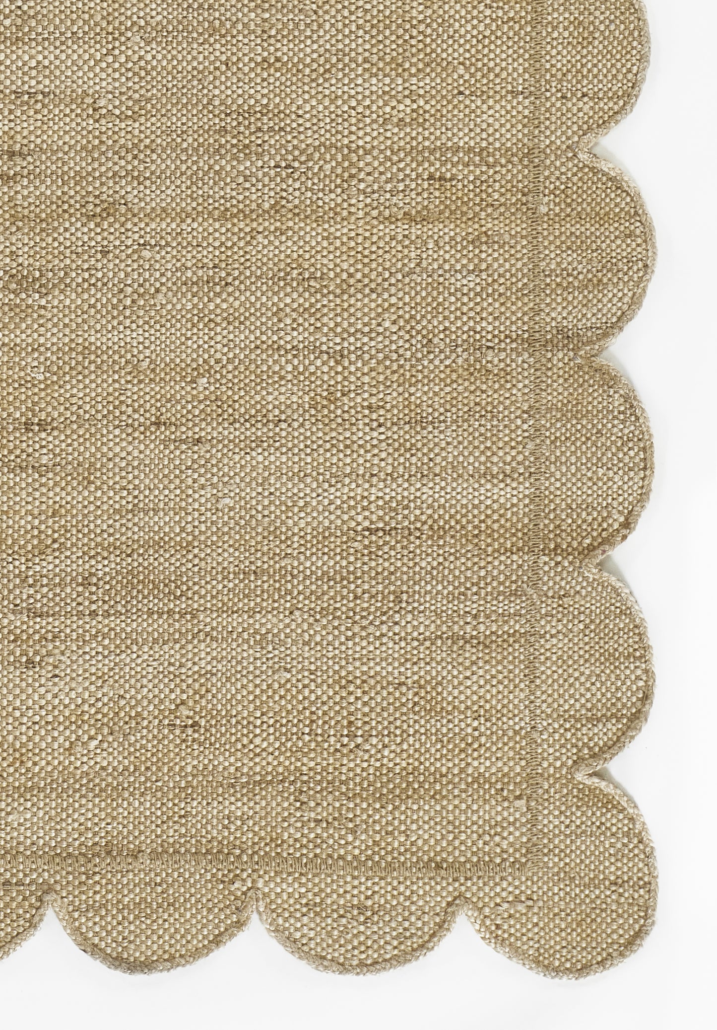 Natural beige woven rug with a jute-like texture and scalloped edge; 8' x 11' rug.