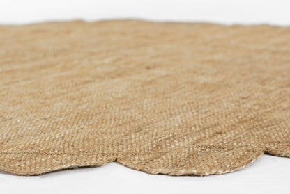 Natural jute round rug with scalloped edge & textured woven fibers in beige.