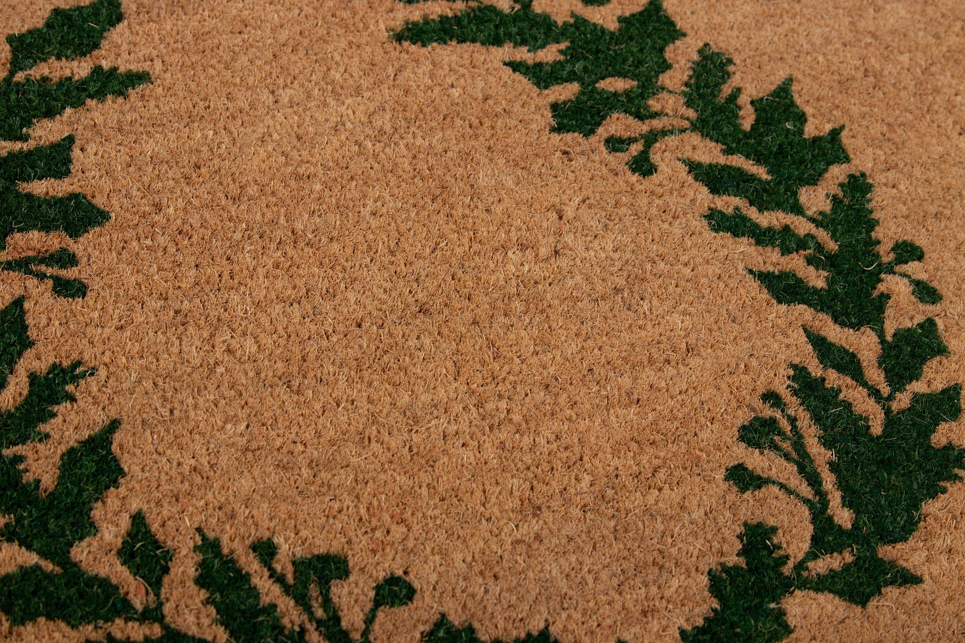 Round cork-textured mat featuring a tan center and a dark green fern border.