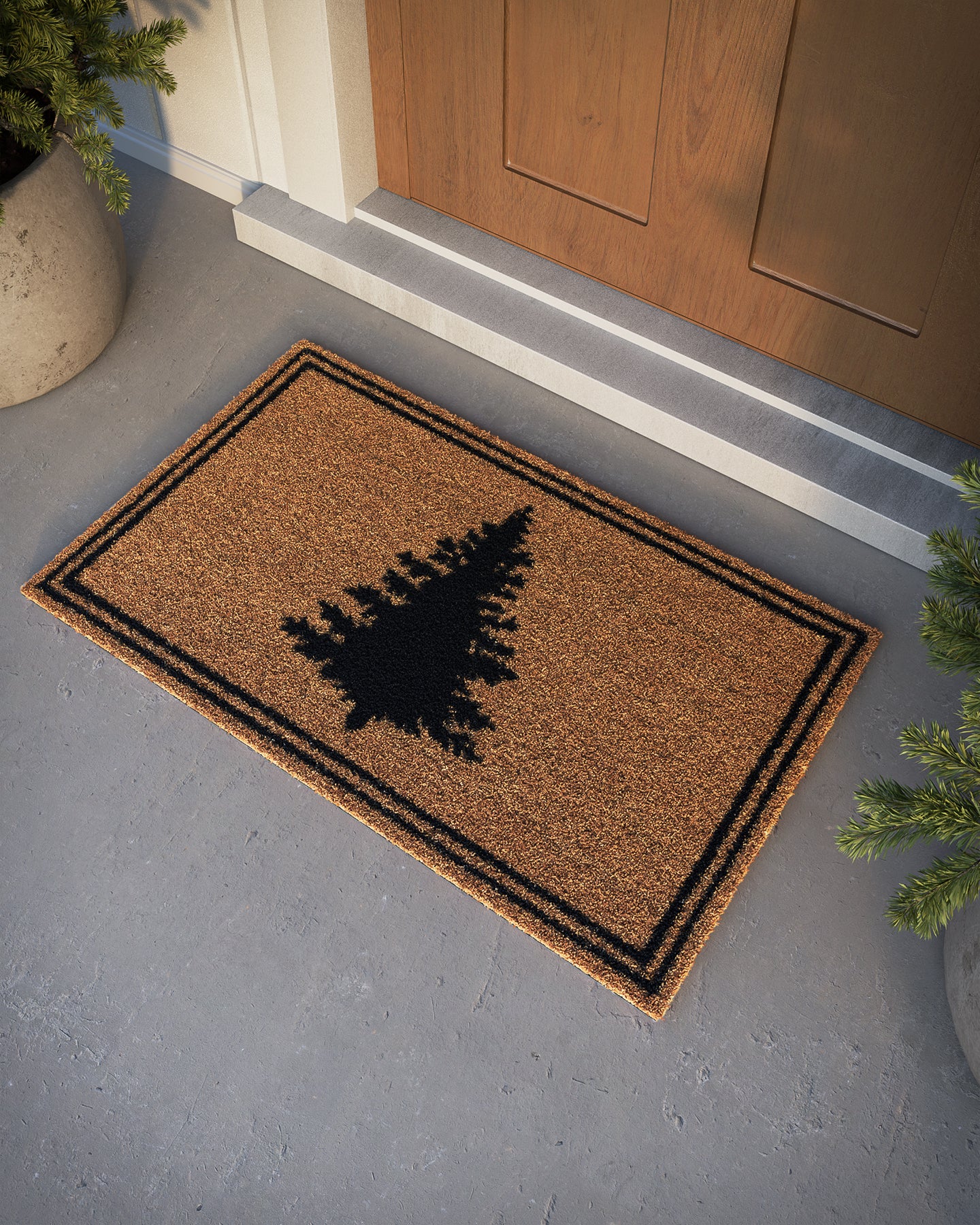 Brown coir doormat with a black pine tree silhouette and double black border.