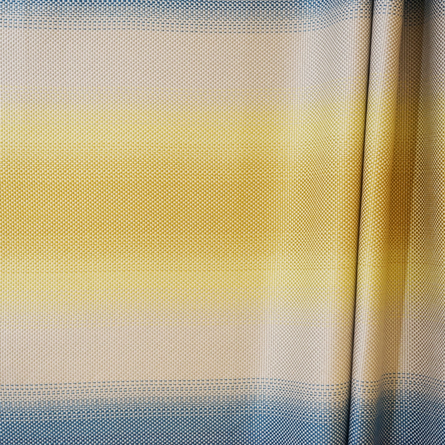 Curtain panel with blue, beige and yellow horizontal gradient and dotted textured fabric.