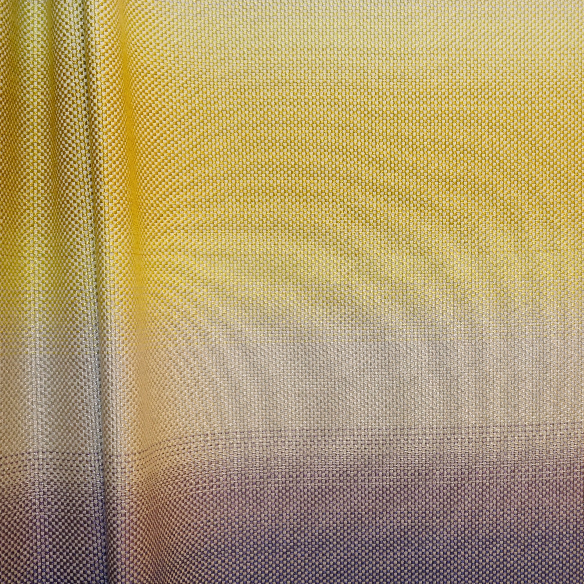 Gradient yellow-to-gray jacquard fabric with a dotted texture; close-up.